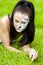 Woman with face art on grass