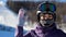 Woman face in a helmet and a mask from cold, frost and wind puts on sunglasses preparing for skiing.Mountaineering ski