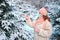 A woman in face mask chooses a live Christmas tree in the forest for the new year. Concept of coronavirus problems for the new