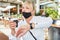 Woman with a face mask on her chin looks at the watch