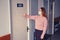 A woman in a face mask knocks on the door of the medical office in the corridor hospital. The problem of receiving patients in the