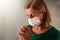 Woman in face mask praying for sick patient