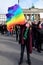 Woman in face mask with rainbow flag, peace symbol. People with Ukrainian flags and placards protest against the war in