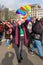 Woman in face mask with rainbow flag, peace symbol. People with Ukrainian flags and placards protest against the war in