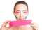 Woman with facelift taping holding roll of kinesiology tape.