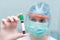 Woman in facemask checking test tube for testing blood for coronavirus. Concept