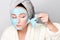 Woman with facial clay mask at spa salon or at home, skincare theme. Girl removes alginate cosmetic mask. Face mask, spa