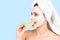 Woman with facial cream mask bites slice grapefruit