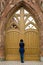 A woman is facing the huge gate of a Catholic church