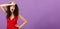 Woman fainting feeling bad whiping sweat of forehead standing drained and exhausted over purple background in red