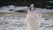Woman in fairy tale image in white chic dress with crown stands on snow