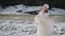 Woman in fairy tale image in white chic dress with crown stands on snow