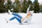 woman falling down while ice skating at winter rink