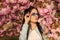 Woman fancy sunglasses in spring flower bloom. Girl in cherry blossom flower. Spring fashion collection. Sakura tree