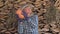 Woman farmer on the background of stacked wood checks the ripeness of pumpkins