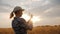 Woman farmer looks at ears of wheat, stands in a field at sunset