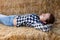 woman farmer lying on strawstack resting during work