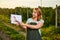 Woman farmer working in fruit garden and shows the level of crop growth using infographics. Biologist inspector examines