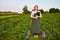 Woman farmer working in a strawberry field. Biologist inspector examines strawberry bushes