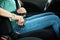 Woman fastening safety belt in car