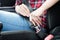 Woman fastening seat belt in car