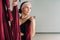 A woman fastens a hook from a hanging hammock for yoga in the gym