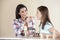 Woman Feeding Ice Cream To Daughter In Parlor