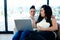 Woman feeding popcorn to her partner while using laptop