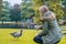 Woman feeds a duck in a park