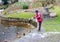 Woman feeds waterfowl ducks on a winter pond near open water. S