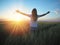 Woman feeling free in a beautiful natural setting, in what field at sunset