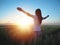 Woman feeling free in a beautiful natural setting, in what field at sunset