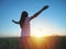 Woman feeling free in a beautiful natural setting, in what field at sunset