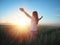 Woman feeling free in a beautiful natural setting, in what field at sunset