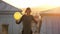 Woman feeling happy walking with raised up hands with balloon on rooftop.