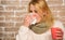 Woman feels badly ill sneezing. Girl in scarf hold tea mug and tissue. Cold and flu remedies. Runny nose and other