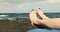 Woman feet closeup relaxing on black sand beach