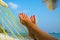 Woman feet in hammock on the beach