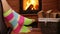 Woman feet hanging on rocking chair, swinging in front of fireplace