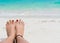 Woman feet and red nails on the beach