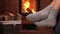 Woman feet resting in rocking chair at fireplace - closeup