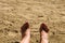 Woman feet in the sand with red painted nails