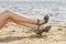 Woman feet in sandals on the beach