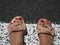 Woman feet in sandals on the pedestrian crossing