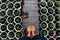 Woman feet stand on path in garden with rhythm of many flower pot