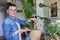 Woman fertilizes monstera plant in pot with mineral fertilizer in sticks at home