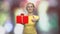 Woman with festive gift box on blurred background.