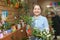 Woman with ficus plant (Bonsai) in store