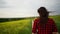 Woman field flowers. Rear view of woman walking in slow motion through a field. A woman is walking alone in a meadow