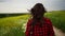 Woman field flowers. Rear view of woman walking in slow motion through a field. A woman is walking alone in a meadow